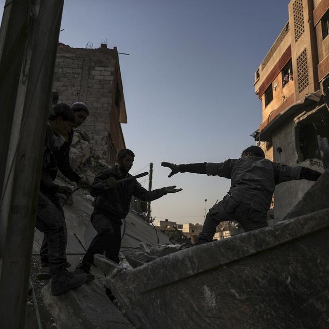 Des soldats cherchent des disparus dans les décombres d'un immeuble à Douma, en Syrie. [Keystone - Mohammed Badra/EPA]