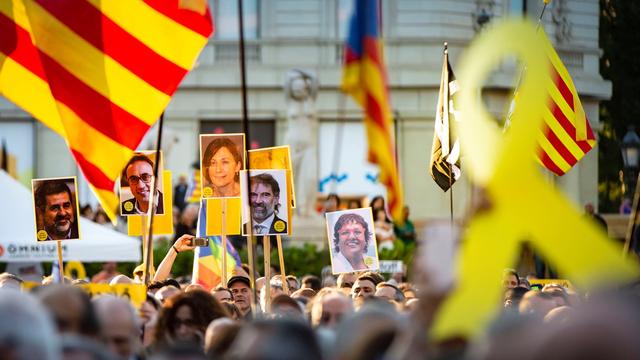 Des manifestants tiennent le portrait des leaders pro-indépendance, arrêtés en novembre 2017. Plaça de Catalunya, Barcelone, le 12 juin 2019. [Keystone/epa - Enric Fontcuberta]