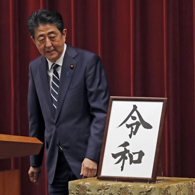 Le Premier ministre japonais, Shinzo Abe, regarde la calligraphie du nom de la nouvelle ère impériale, "Reiwa". [Keystone/ap photo - Eugene Hoshiko]