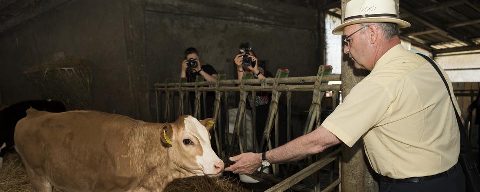 Le Conseiller federal Guy Parmelin a visité trois fermes vaudoises lors de la journée "Portes ouvertes à la ferme". [Keystone - Jean-Christophe Bott]