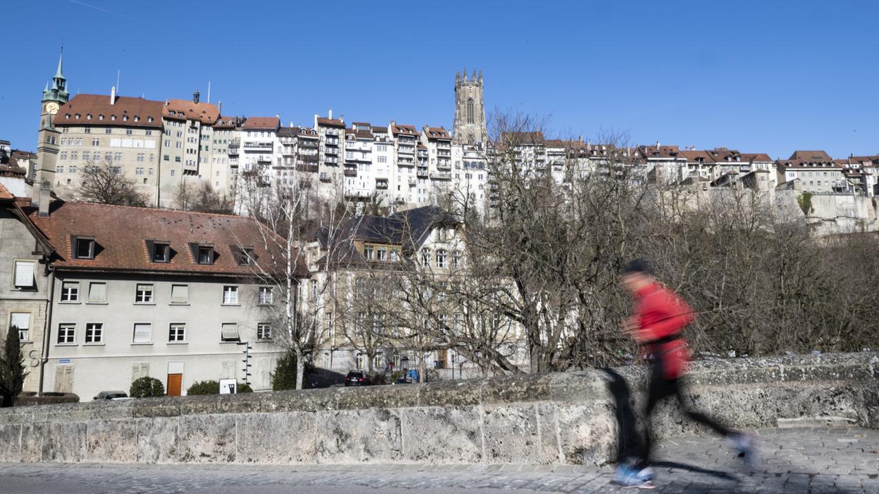 Une personne fait de la course à pieds en Basse-Ville de Fribourg. [Keystone - Adrien Perritaz]