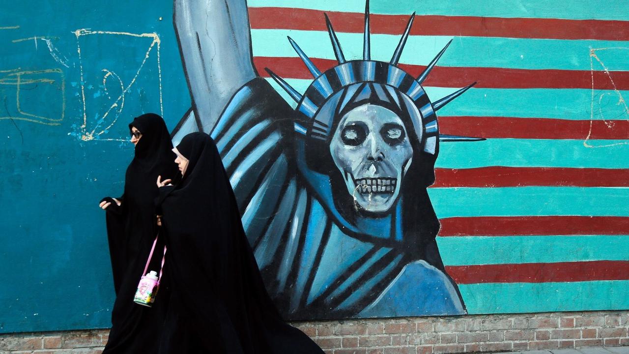 Deux Iraniennes pasent devant une peinture murale anti-américaine à Téhéran en 2016. (Image d'illustration). [EPA - ABEDIN TAHERKENAREH]