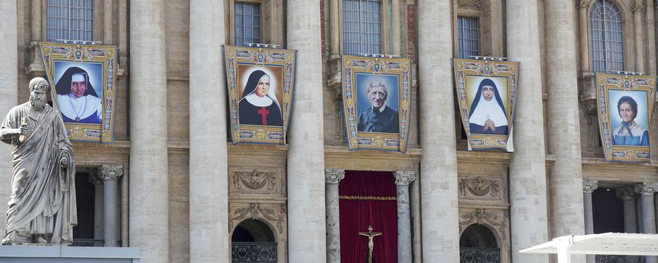 Marguerite Bays (à droite) sur la façade de la Basilique St-Pierre au Vatican. [Keystone - AP/Andrew Medichini]