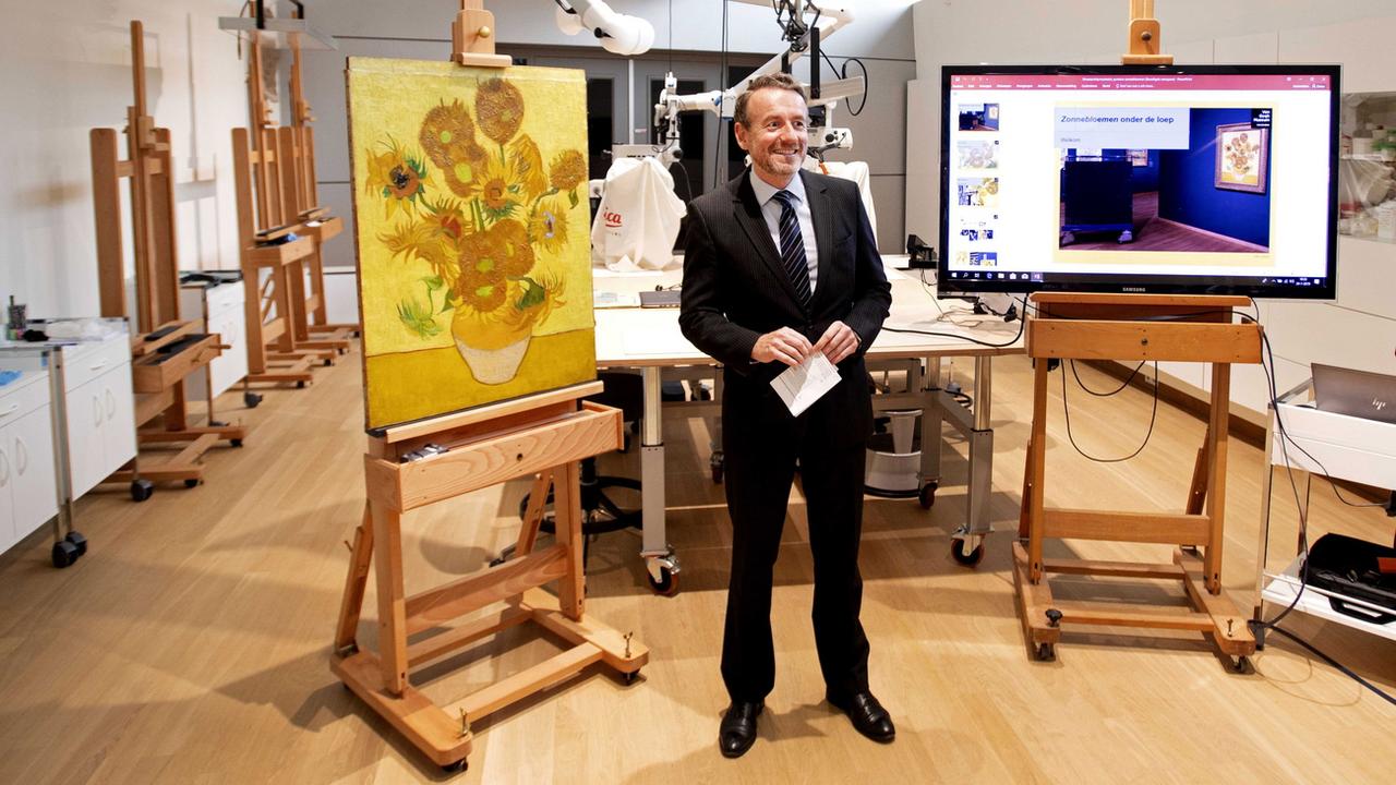 Axel Ruger, directeur du Musée Van Gogh d'Amsterdam, explique la restauration effectuée pendant six semaines sur le tableau "Les Tournesols". [Keystone/epa - Olaf Kraak]