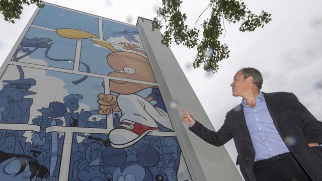 Zep devant une fresque inaugurée en mai 2019 sur un immeuble du quartier d'Onex, à Genève [Keystone - Martial Trezzini]