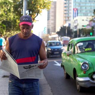 Un Cubain lisant une version imprimée du projet de nouvelle Constitution. [Keysatone/EPA - Yander Zamora]