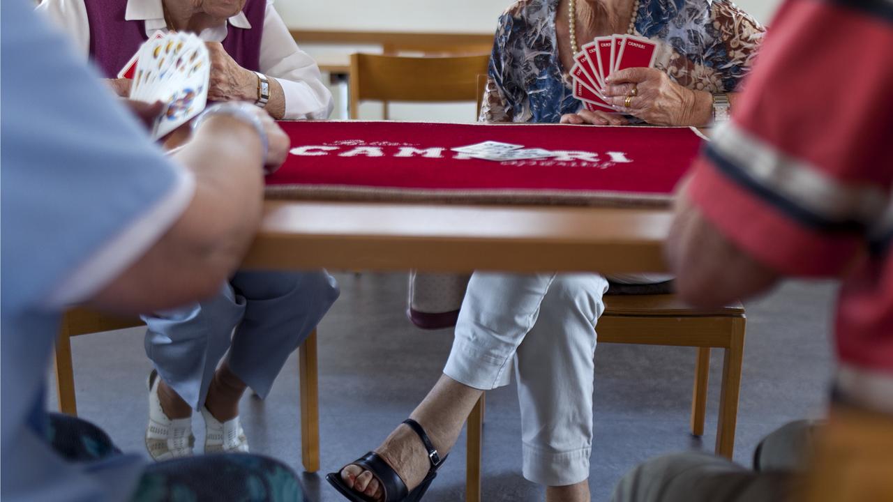 Des personnes âgées jouant aux cartes à Zurich. [Keystone - Martin Ruetschi]