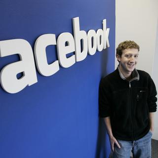Mark Zuckerberg devant le logo de Facebook en 2007. [Keystone - AP Photo - Paul Sakuma]
