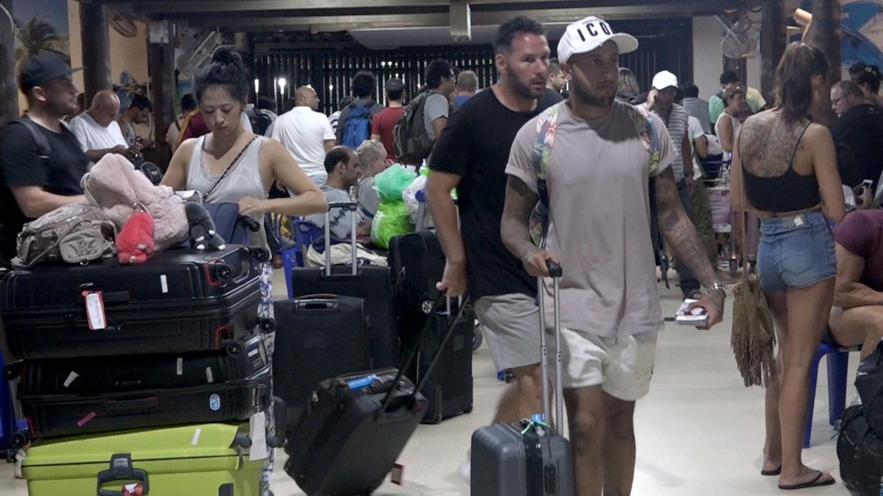 Des touristes à l'aéroport de Koh Samui, où leur vol a été annulé en raison de la tempête tropicale. [EPA/Keystone - Sitthipong Chareonjai]