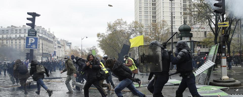 Des policiers confrontés à des manifestants à Paris. [Keystone/EPA - Yoan Valat]