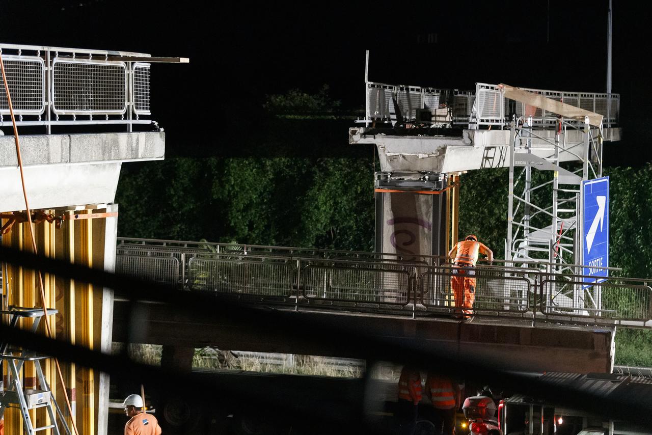 Les travaux de démolition de la passerelle, dans la nuit de lundi à mardi. [KEYSTONE - Cyril Zingaro]