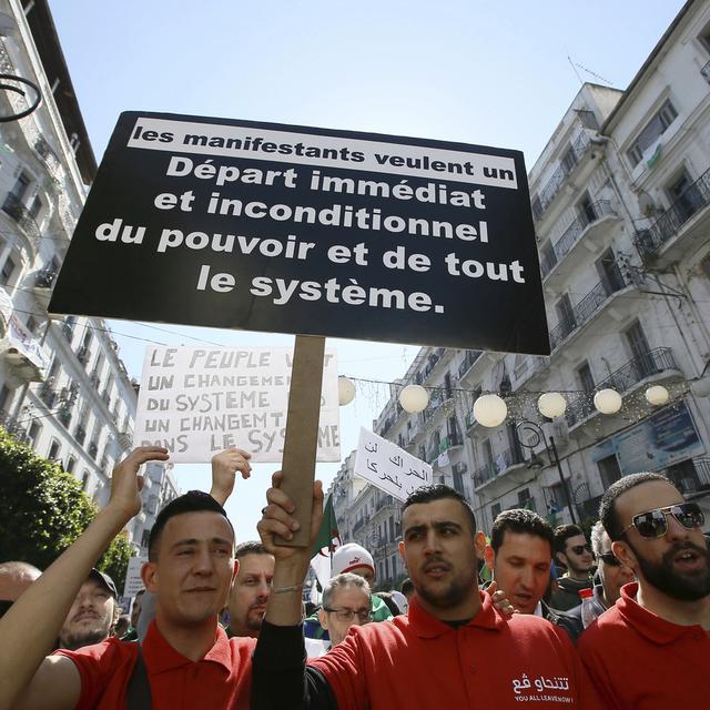 Des manifestants algériens demandent le départ immédiat du gouvernement en place. [Keystone - Anis Belghoul / AP Photo]