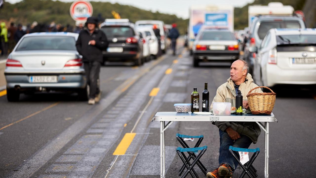 Un indépendantiste catalan installé sur l'autoroute à la frontière franco-espagnole. [Keystone - EPA/David Borrat]