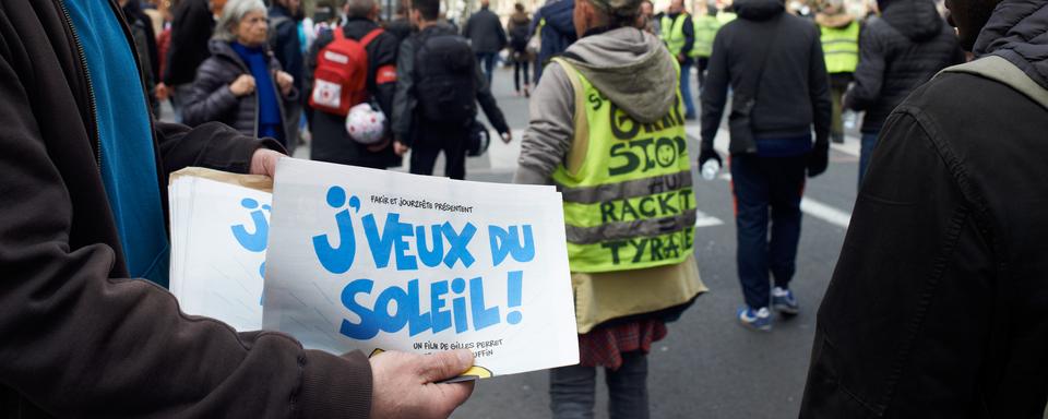 Un flyer pour le documentaire de François Ruffin, "J'veux du soleil", distribué pendant une manifestation des "gilets jaunes". [AFP - Alain Pitton/NurPhoto]