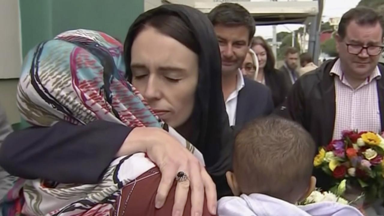 Jacinda Ardern (de face) tente de consoler une femme lors d'un hommage aux victimes de la tuerie de Christchurch. [KEYSTONE - AP TVNZ]