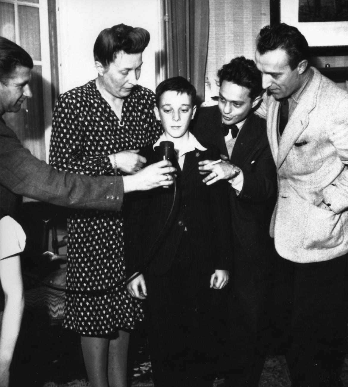 Juliette Hédiguer, la première personne à formuler un voeu dans le cadre de la Chaîne du Bonheur, ici avec Roger Nordmann et Jack Rollan, lors de la première émission le 26 septembre 1946. [Keystone - La Chaîne du Bonheur / HO]