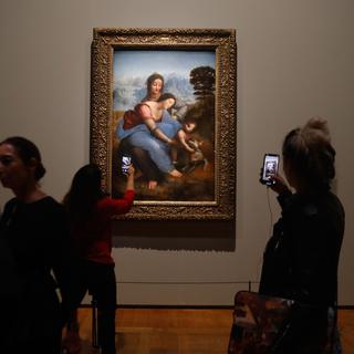 Des visiteurs de l'exposition Leonardo da Vinci" au Louvre à Paris devant la peinture "La Vierge, l'enfant Jésus et Saine Anne". [AFP - François Guillot]