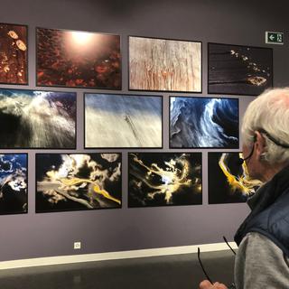 Yann Arthus-Bertrand face à ses photos à la fondation Opale à Lens. [RTS - Karine Vasarino]
