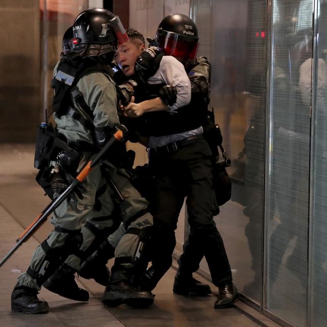 La police anti-émeute brutalise un homme à Hong-Kong, le 12 novembre 2019. [AP Photo/Keystone - Ng Han Guan]