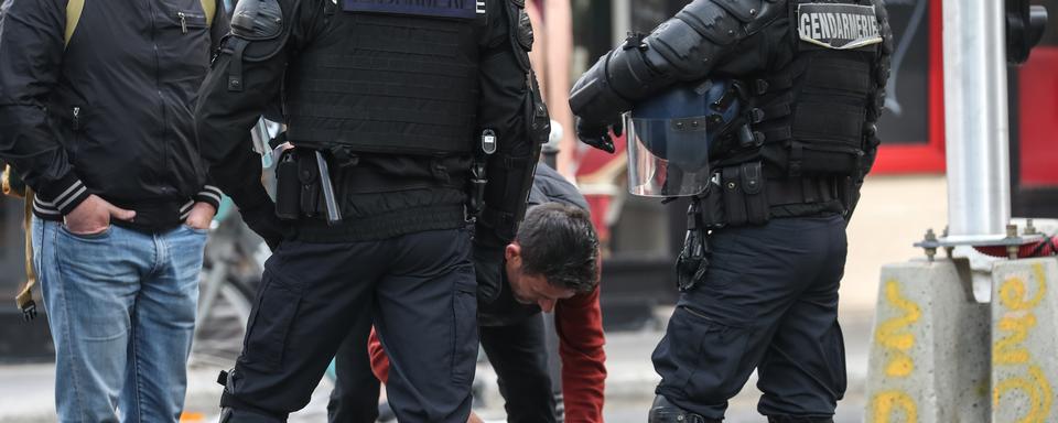 Des gendarmes fouillent les manifestants avant la manifesation du 1er mai. [AFP - Kenzo Tribouillard]