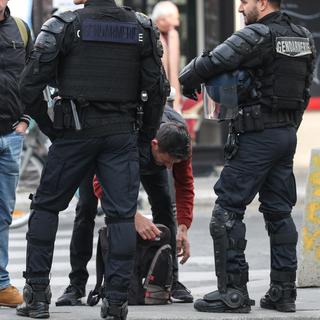 Des gendarmes fouillent les manifestants avant la manifesation du 1er mai. [AFP - Kenzo Tribouillard]