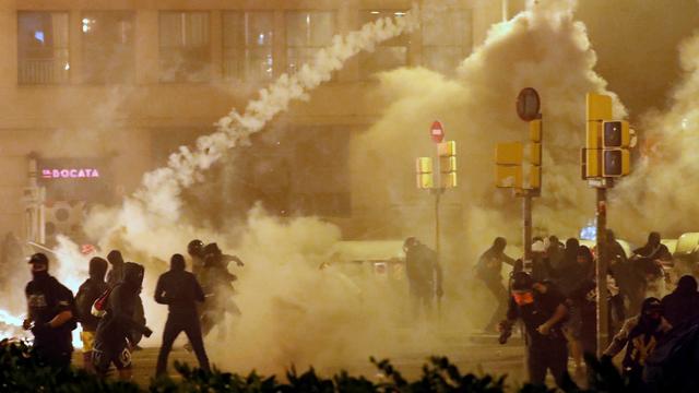 Des manifestants renvoient à la police un projectile de gaz lacrymogènes. Barcelone, le 18 octobre 2019. [Reuters - Jon Nazca]