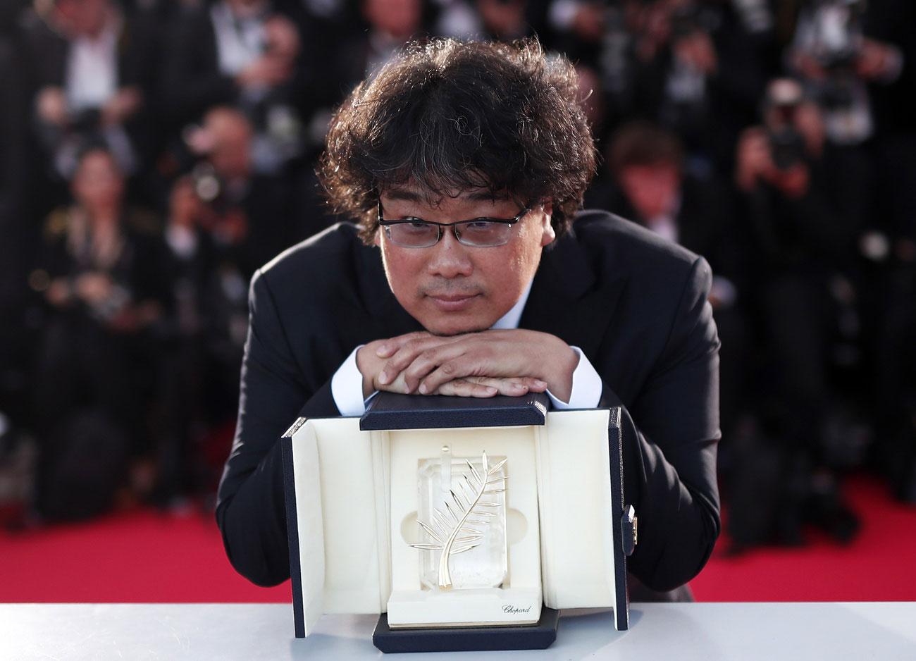 Le réalisateur coréen Bong Joon-ho pose avec sa Palme d'or pour son film "Parasite" lors de la 72e édition du Festival de Cannes. [Keystone - Ian Langsdon]
