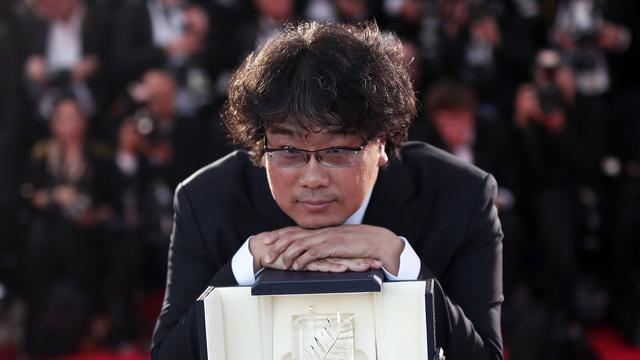 Le réalisateur coréen Bong Joon-ho pose avec sa Palme d'or pour son film "Parasite" lors de la 72e édition du Festival de Cannes. [Keystone - Ian Langsdon]