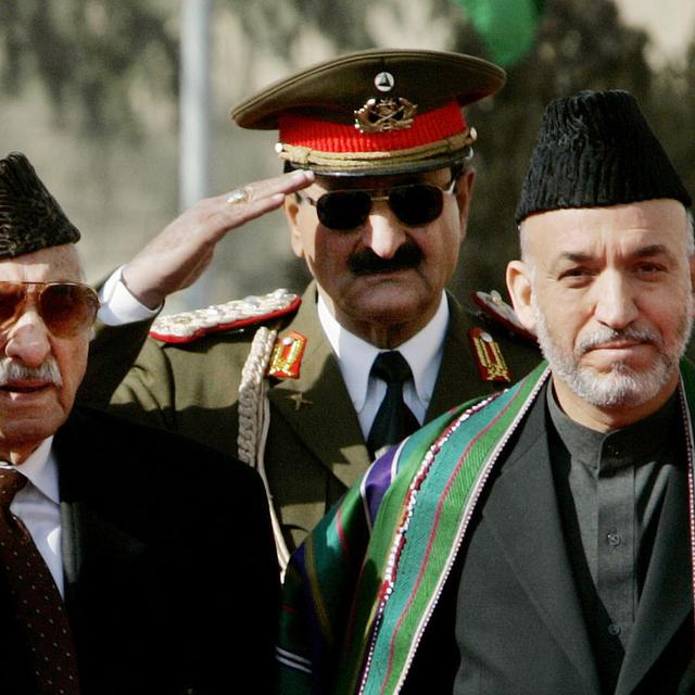 A droite, le président afghan Hamid Karzaï à Kaboul en décembre 2004 lors de la cérémonie d'investiture qui lui rend hommage en tant que premier président élu par le peuple. A gauche, l'ancien roi Mohammad Zaher Shah. [KEYSTONE/AP Photo/ - Larry Downing]