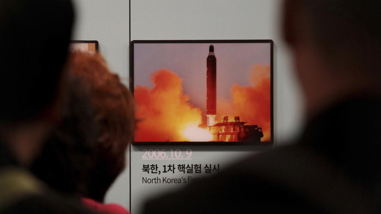 Des visiteurs devant une photo de lancement d'un missile nord-coréen, à Paju, en Corée du Sud, le 19 avril 2019. [AP Photo - Ahn Young-joon]