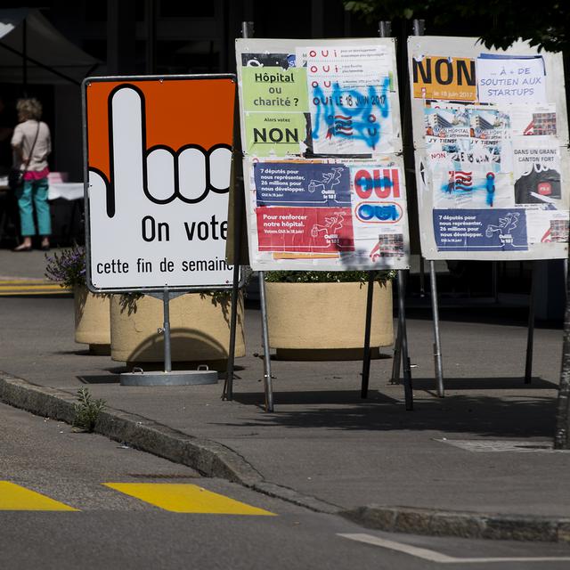 Des panneaux avec des affiches électorales un jour avant le scrutin historique censé régler l'appartenance cantonale de la ville le 18 juin 2017. [Keystone - Jean-Christophe Bott]