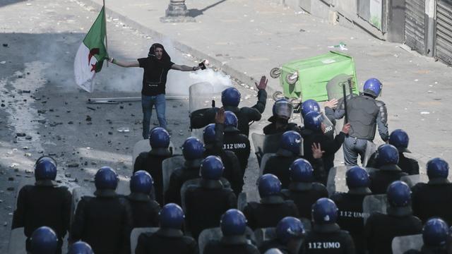 Un manifestant face à la police à Alger. [AP Photo/Keystone - Mosa'ab Elshamy]