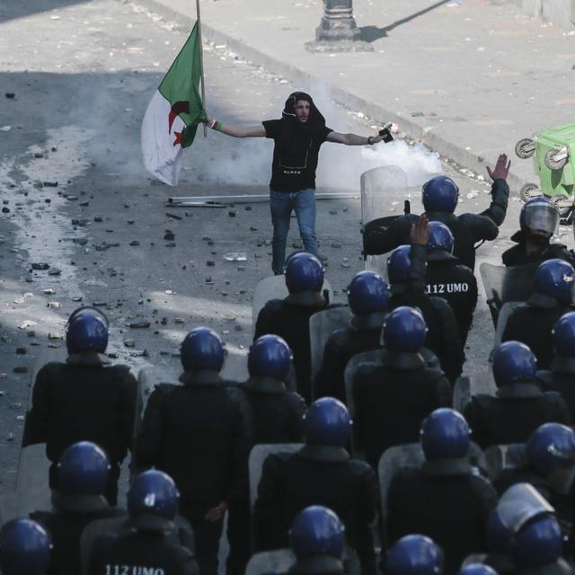 Un manifestant face à la police à Alger. [AP Photo/Keystone - Mosa'ab Elshamy]