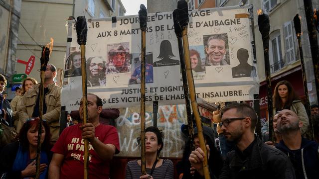 Huit torches ont été allumées en mémoire des victimes de l'effondrement de deux immeubles à Marseille. [AFP - Christophe Simon]