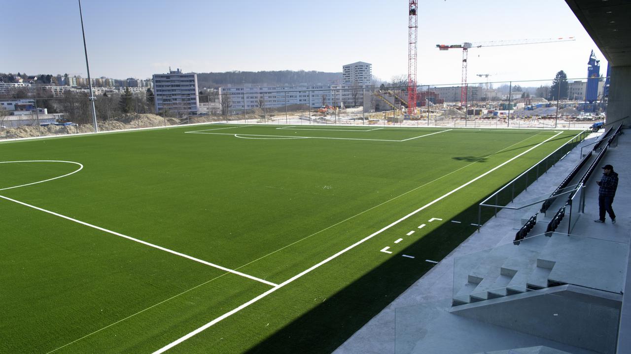 Le terrain principal synthétique du Centre de la Tuilière avec au fond le chantier du stade. [Keystone - Laurent Gilliéron]