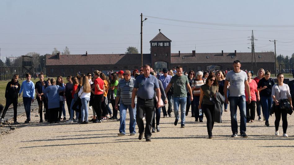 Des visiteurs du camp de concentration d'Auschwitz-Birkenau en Pologne, en octobre 2018. [Keystone - Helmut Fohringer]