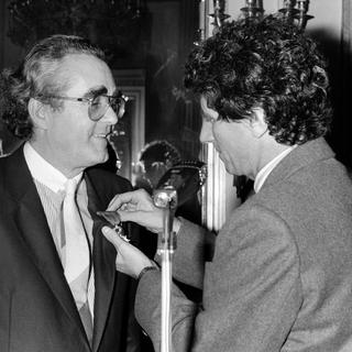 Jack Lang, ministre de la culture, remet la médaille de la Légion d'honneur à Michel Legrand le 13 novembre 1984. [KEYSTONE/RUE DES ARCHIVES/AGIP]