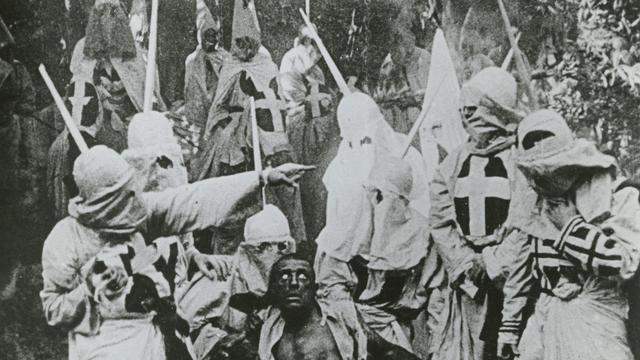 Membres du Ku Klux Klan entourant l'esclave affranchi Gus (joué par l'acteur blanc Walter Long) dans une scène de "Naissance d'une nation" ("The Birth of a Nation"), réalisé en 1915 par D. W. Griffith.