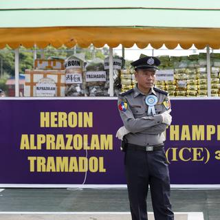 Un policier birman surveille un stock de drogue saisi dans le cadre des opérations anti-narcotiques [EPA/Keystone - Nyein Chan Naing]