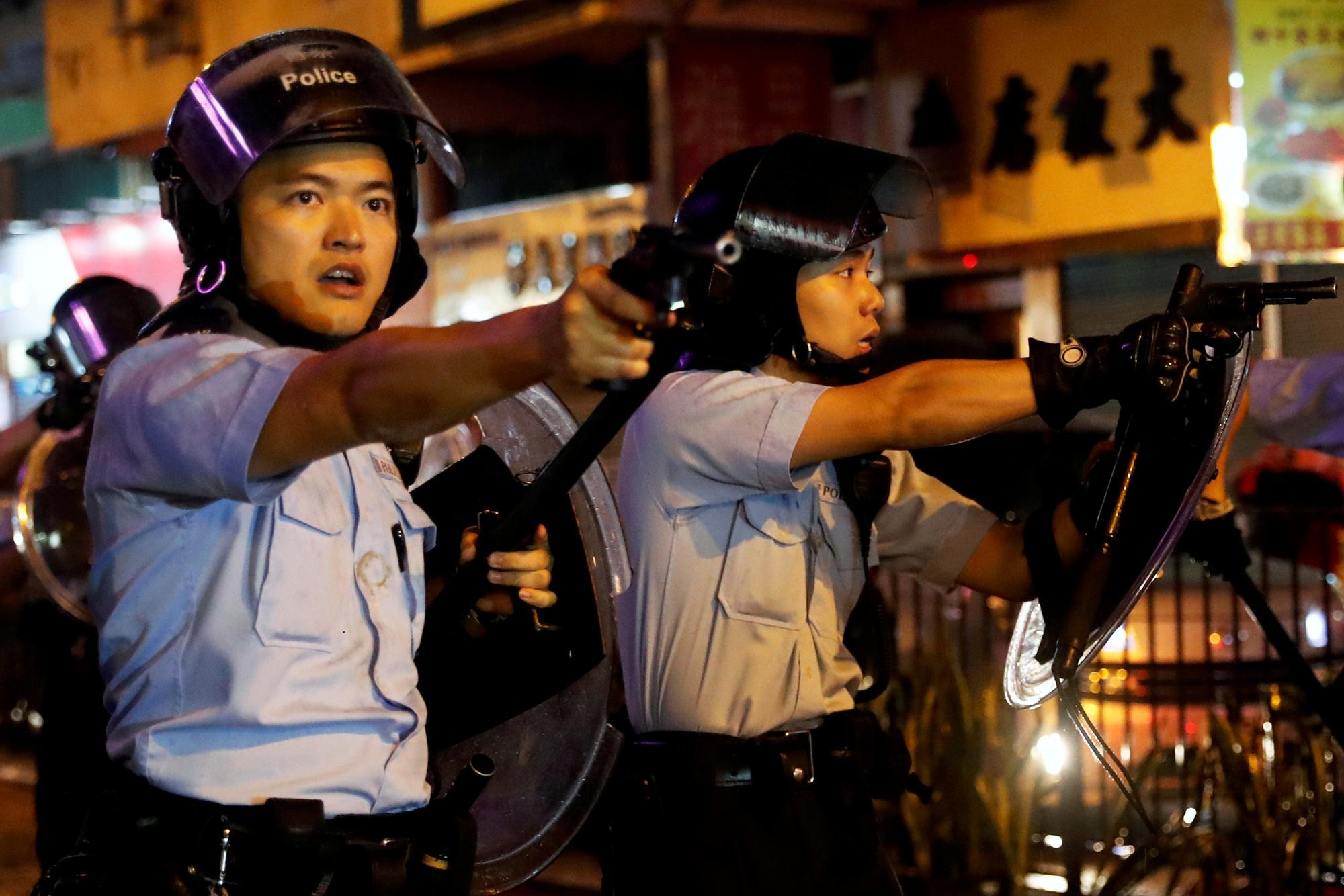 Des policiers sortent leur pistolet après une confrontation à Tsuen Wan, Hong Kong, le 25 août 2019. [Reuters - Tyrone Siu]