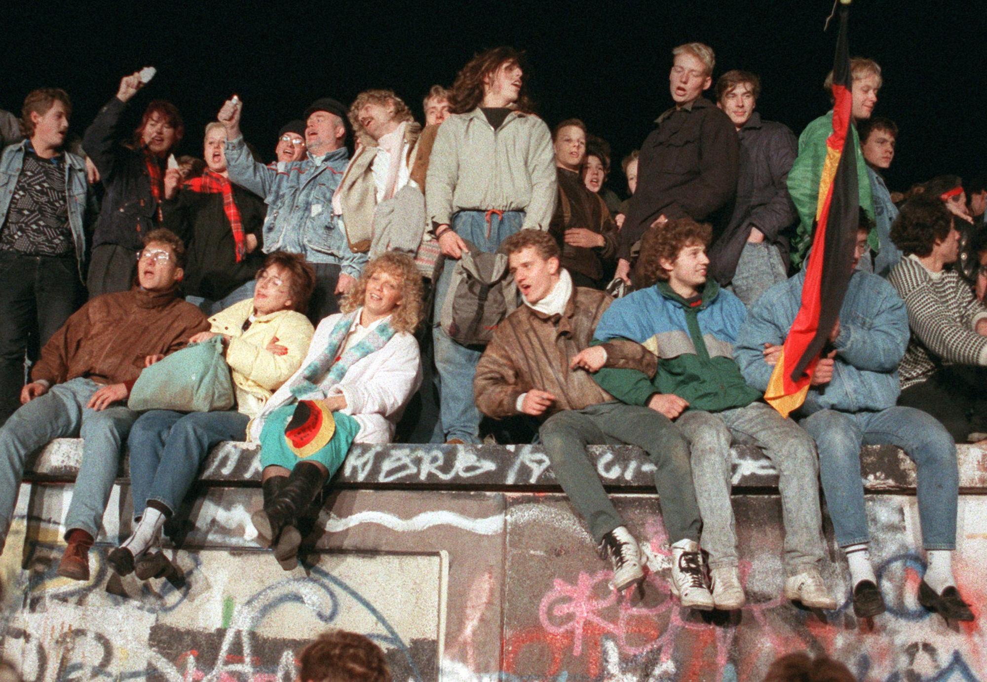 Des jeunes gens qui chantent sur le mur de Berlin le 10 novembre 1989. [dpa Picture-Alliance/AFP - Peter Kneffel]