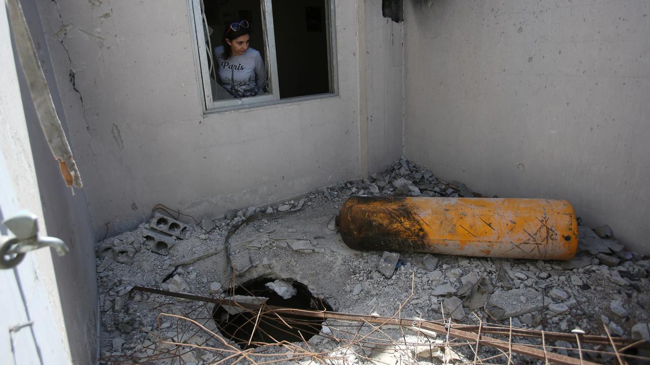 Une journaliste examine une maison endommagée: celle-ci a reçu la visite de l'Organisation pour l'Interdiction des Armes Chimiques. Douma, Syrie, 23 avril 2019. [Reuters - Ali Hashisho]