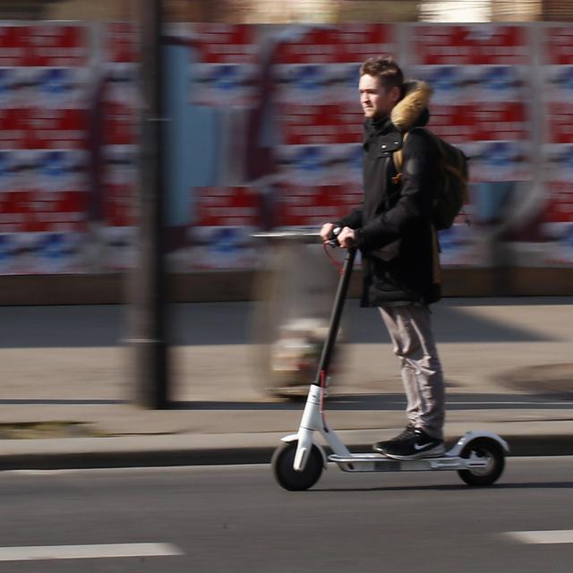 Un jeune en trottinette électrique à Paris. [AP/Keystone - Francois Mori]