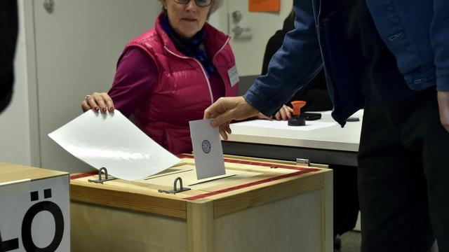 Un électeur dépose son bulletin dans l'urne lors des élections législatives, le 14 avril 2019 à Helsinki. [AP/Keystone - Emmi Korhonen]