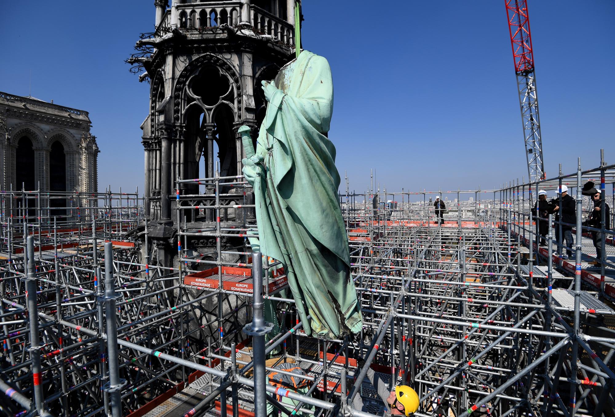 L'hélitreuillage des statues qui ornaient la flèche de Notre-Dame, emmenées en restauration jeudi dernier. [AFP - Bertrand Guay]