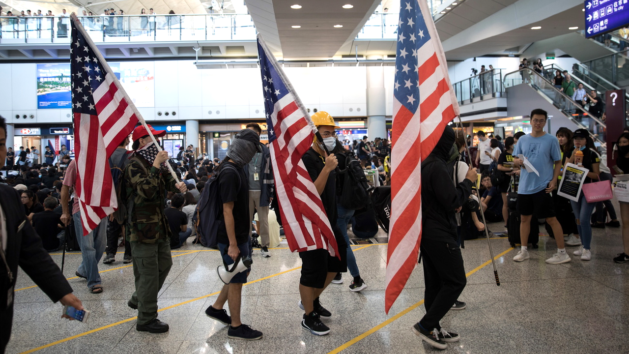 Manifestants portant le drapeau américain lors d'un sit-in à l'aéroport de Hong Kong, 09.08.2019. [EPA/Keystone - Jérôme Favre]