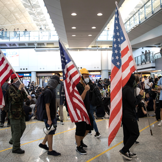 Manifestants portant le drapeau américain lors d'un sit-in à l'aéroport de Hong Kong, 09.08.2019. [EPA/Keystone - Jérôme Favre]