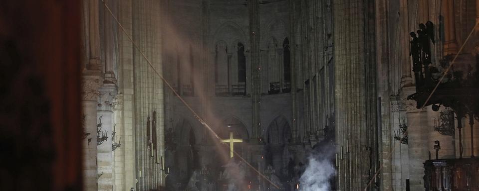 L'intérieur de Notre-Dame, alors que l'incendie est maîtrisé dans la nuit. [AP/Keystone - Philippe Wojazer]