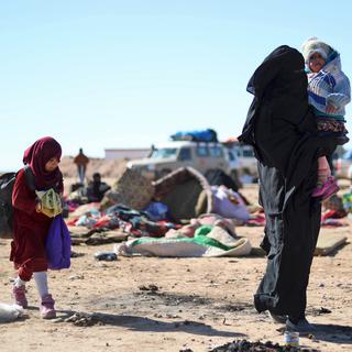 Une femme et ses enfants qui a fuit les combats entre le groupe Etat islamique et les Forces démocratiques syriennes dans la province de Deir Ezzor en Syrie. [AFP - Delil Souleiman]