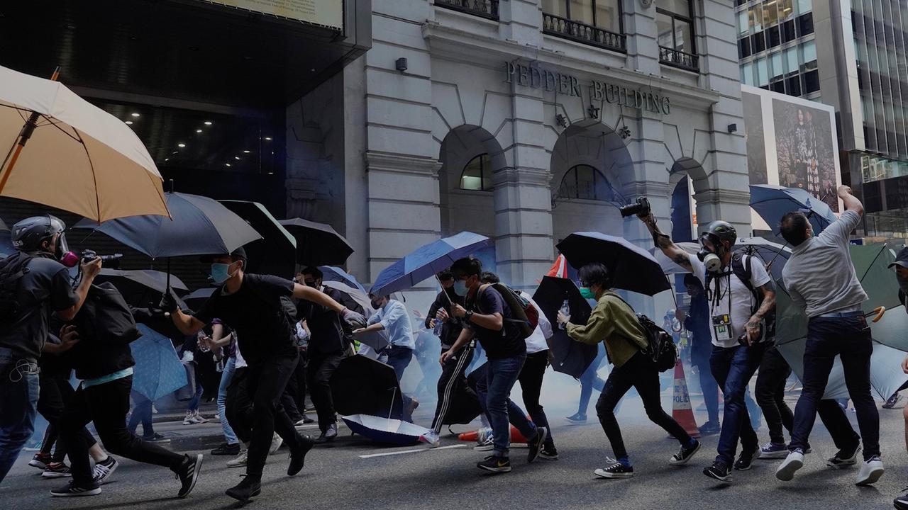 Des manifestants hongkongais tentent d'échapper aux gaz lacrymogènes. [AP Photo/Keystone - Vincent Yu]
